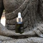 Ethical Brands - Black Glass Bottle on Man Statue