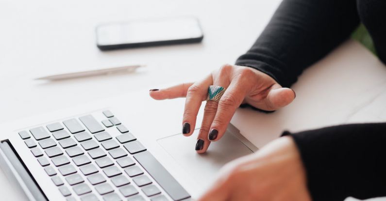 Turnaround Strategies - Crop female using touchpad on laptop in office